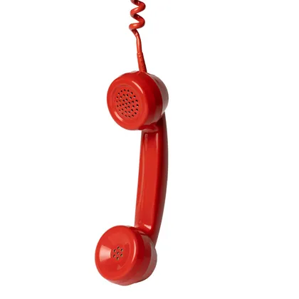Red phone handset hanging by its cord